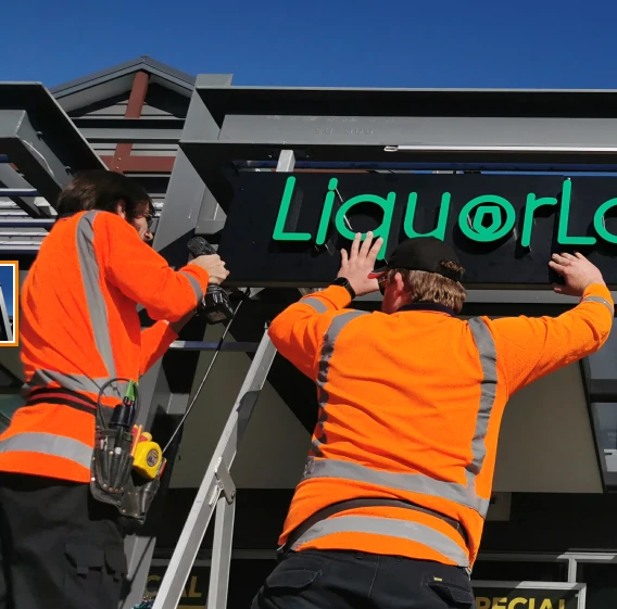 Electricians install outdoor sign from neon nights at LiquorLand Rototuna